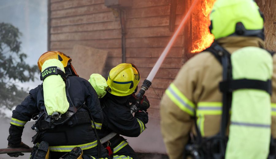 Sopimsupalokuntalaisia sammutusharjoituksissa sammuttamassa palavaa rakennusta
