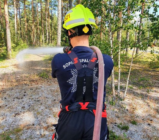 Sopimuspalokuntalainen suihkuttamassa vettä