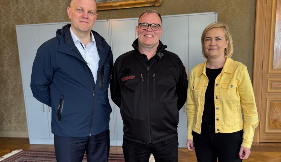 Sisäministeri Mari Rantanen ja valtiosihteeri Heikki Tamminen SSPL:n Ari Maskosen kanssa seisomassa yhteiskuvassa.