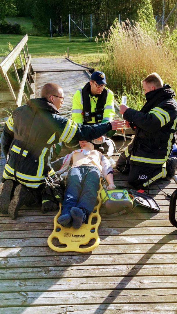 Sopimuspalokunnan ensiauttajia elvyttämässä harjoitusnukkea laiturilla