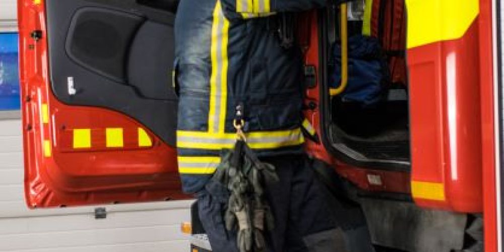 Sopimuspalokuntalainen sammutusasussa nousemassa paloauton kyytiin