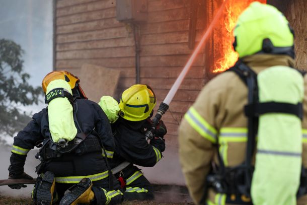 Sopimsupalokuntalaisia sammutusharjoituksissa sammuttamassa palavaa rakennusta